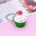 Detalle de un llavero de cupcake de 3 capas con corazón rojo y base de papel verde - Verde