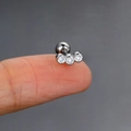 Silver curved barbell ear stud with three clear zircons on a fingertip for size - 5# (White Gold)