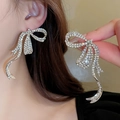 Elegant silver bow earrings with sparkling rhinestones shown on model and close-up - Large Bowknot Tassel Style (10#银针-银色)