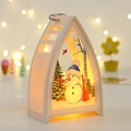Primer plano de un farol de Navidad LED blanco con dibujo de muñeco de nieve y luz - Candelabro Navideño Triangular - Muñeco De Nieve Blanco