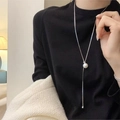 Detail of adjustable long pearl necklace with silver chain on a black outfit - Silver