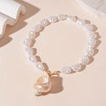 Detalle de colgante de caracola con perlas barrocas blancas en collar dorado estilo marino - Collar de Perla Grande de Caracola