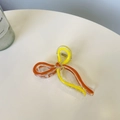 Detail of a resin bow hair claw clip with yellow and orange ribbons and gold spring - Approx. 9.5cm / Yellow + Orange