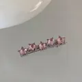 Detail einer silbernen Haarspange mit fünf schimmernden rosa Strasssternen in einer Reihe - Fünf Sterne / Rosa