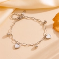 Macro detail van zilveren roestvrijstalen enkelbandje met witte hartjes en stalen kraaltjes - Hart Staal Armband