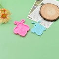 Flat lay of pink and light blue bee-shaped silicone molds for DIY resin crafts - Vertical Bee