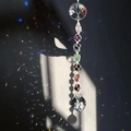Close-up of a handmade 7 chakra tree of life suncatcher with multi-colored healing crystals - Round Tree of Life