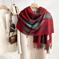 Detailed view of red and green plaid scarf with soft fringe and GOOD LUCK fabric label - Red