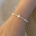 Detail of beaded alphabet bracelet with letter L pearl and golden spacer accents - Letter L Style (L)