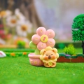 Detailed close-up of a resin lion figurine with a pink rich flower pot on green grass - A187 Rich Flower
