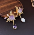 Details asymmetrischer Goldohrringe mit lila Kristallen und weißen Süßwasserperlenanhängern - Asymmetrischer Schmetterling Rohstein Perlen Stil / Gold (Silberner Ohrringstecker)