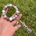 Detailed shot of silicone beaded keychain bracelet with leopard print tassel on green grass - Purple Leopard Pattern Combination (A5)