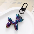 Macro detail of iridescent metallic balloon dog keychain with black lobster clasp in a tray - Black