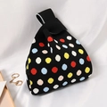 Knitted wrist bag in black with colorful polka dots on white satin background - Rainbow Dot Black