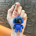 Creative blue astronaut robot keychain pendant for bags and cars, shown held in hand. - Blue