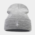 Dettaglio del ricamo bianco su un berretto in maglia grigio scuro con trama calda - Grigio chiaro