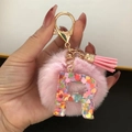 Pink faux fur pompom keychain with resin letter R and colorful heart sequins - Letter R