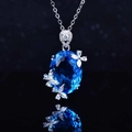 Silver pendant necklace with large oval blue gemstone and white floral accents - Tz-21