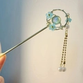 Detailed shot of golden metal hair pin with blue flowers, pearls, and tassel chain - Cat's Eye Stone Blue