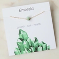 Gold chain necklace with irregular green emerald stone pendant on white marble background - Emerald