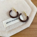Detailed view of dark brown round hoop earrings on a beige fabric pouch - Dark Coffee