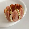 Détail du bracelet élastique doré en acrylique avec modules à texture de marbre rose - Violet