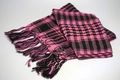 Close-up of pink and black checkered desert scarf with decorative fringe details - Pink