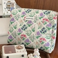 Detailed view of quilted floral cosmetic bag featuring a vintage pattern and brand label - Retro Flower Cluster