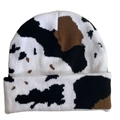 Detail of a cow print knit beanie with black white and brown spots on a white background - Cow Print - Black/White/Brown