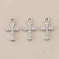 Close-up of three silver baroque cross charms with clear gemstones on beige fabric - Beige Geometric / 1.2*0.7cm / Silver