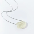 Detailed top view of a minimalist silver chain with an irregular raw yellow crystal pendant - Citrine