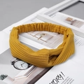 Detail of mustard yellow ribbed knit headband with elegant twisted knot design and texture - Knitted Yellow