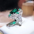 Macro view of emerald green square cut gemstone ring with micro pave diamond halo - Adjustable Open / Green