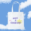 White canvas tote bag with purple Have a Good Day print and yellow stars under blue sky - Have A Good Day / Purple Stars