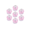 Acht rosa facettierte Acrylperlen mit großen Löchern für DIY-Schmuck auf weißem Hintergrund - Rosa