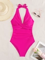 Magenta ruched one-piece halter swimsuit with bow tie on textured sand background - Rose Red