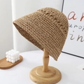 Detailed macro view of the brown woven straw bucket hat with intricate hollow-out texture - Khaki