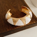 Vista macro detallada del brazalete esmaltado en oro y blanco sobre madera - Dorado-Blanco-Ancho