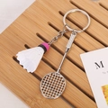Detailed view of mini badminton racket and shuttlecock keychain on a wooden tray - Racket With Clasp / White (Pink Head)