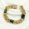 Macro dettaglio del bracciale a catena cubana d'oro con smeraldi e chiusura di diamanti - Oro Verde