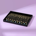 Golden necklaces with clover and flower charms on a black velvet jewelry tray - Black
