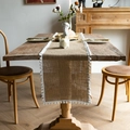 Detail of natural brown jute table runner with white pom-pom lace trim on wooden table - White Ball Fringe