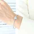 Silbernes gedrehtes Herzarmband aus poliertem Edelstahl für modische Damen - Armband + Ring Set / Stahlfarbe