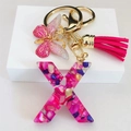 Macro detail of resin letter X keychain with pink stones, gold butterfly and tassel - Rose Red Butterfly Tassel Clip / Letter X