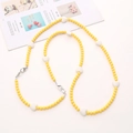 Tracolla in perline acriliche gialle con cuori bianchi e chiusure argentate su superficie bianca - Cuore 2-in-1 Crossbody / Giallo