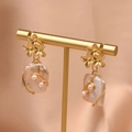 Elegant gold flower earrings with baroque pearls on a professional display stand - Baroque Pearl Drop Earrings