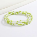 Macro shot of green and white glass seed bead body chain on a clean white background - Bright Green White