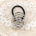 Minimalist elastic hair tie with a silver spiral metal bead on lace background - Silver Line Spiral
