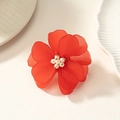 Primer plano de anillo de flor acrílica roja mate con perlas sobre plato cerámico - Rojo