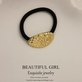 Minimalist black elastic hair tie with a textured gold hammer-finish metal cuff - Small Oval Pattern Gold
